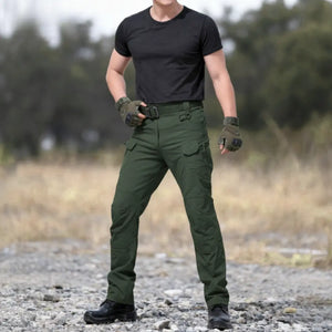 Um homem usando a Calça Tática Masculina RipStop na cor verde em cenário desértico