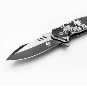 A lâmina do Canivete Tático Albatroz Krait em foco, mostrando seu design e seus furos no dorso