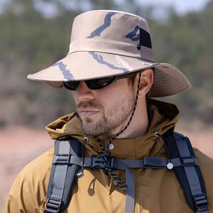 Um aventureiro mostrado de lado, usando um óculos escuro e o Chapéu de Pesca Zanter Camo Trek na cor caqui