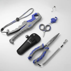 Alicate bico longo carbon e sua bainha, tesoura trimmer e seu chaveiro e alicate de contenção clamp deitados sobre uma mesa cinza