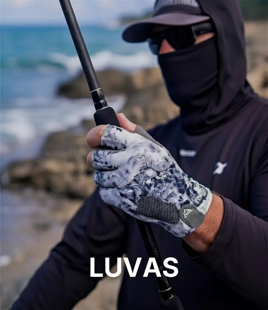 Um pescador na costeira de uma praia usando uma camisa preta, óculos boné e uma luva de pesca camuflada na cor cinza, abaixo está escrito "luvas"