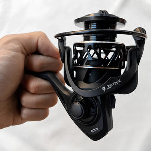 Uma mão segurando o Molinete de Pesca Zephyr Tamanho 4000, para ilustrar seu tamanho