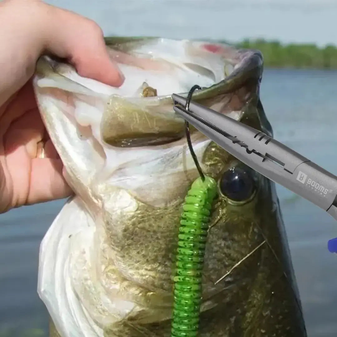 Pescador segurando um peixe, enquanto a outra mão remove a isca artificial da boca dele com o Alicate de Pesca Bico Longo Booms Carbon