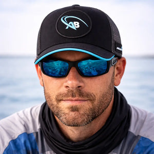 Pescador mostrado de frente utilizando o  Boné de Pesca Angler Signature usando um óculos de sol e uma camisa de pesca térmica