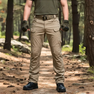 A Calça Tática Masculina RipStop na cor caqui sendo usada por um homem e vista de frente, com uma floresta ao fundo