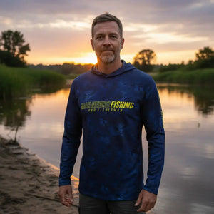 Um pescador visto de frente as margens de um rio com os braços esticados usando a Camisa de Pesca Mar Negro Sublimada Capuz Blue