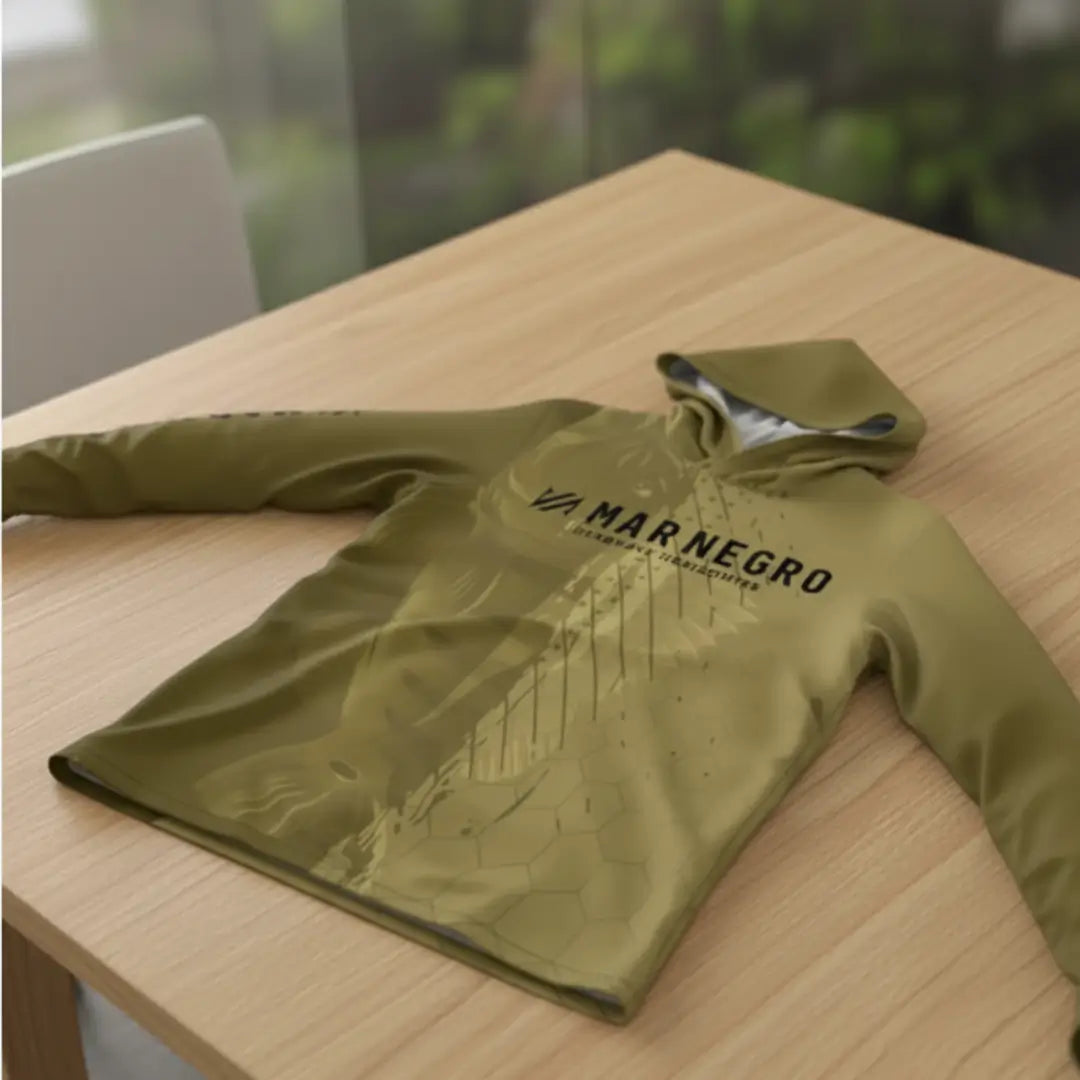 A Camisa de Pesca Mar Negro Sublimada Capuz Tucuna em foco, em cima de uma mesa marrom