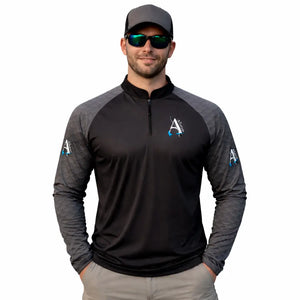 Um pescador mostrado de frente vestindo a Camisa de Pesca Onyx, um óculos escuro e um boné, ele está com as duas mãos nos bolsos da bermuda