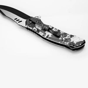 O Canivete Tático Albatroz Krait sendo mostrado sobre uma mesa, com seu clip de bolso e seu cabo em foco