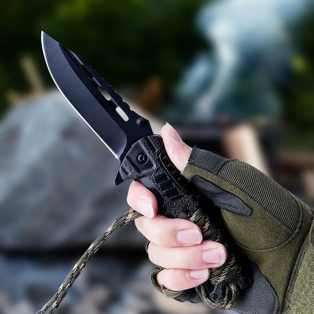 Uma mão com uma luva segurando o Canivete Tático Talon