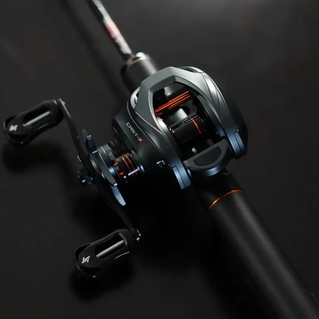 Carretilha SEASIR Cast-X2 montada em vara de pesca com detalhes em preto e laranja sobre fundo escuro