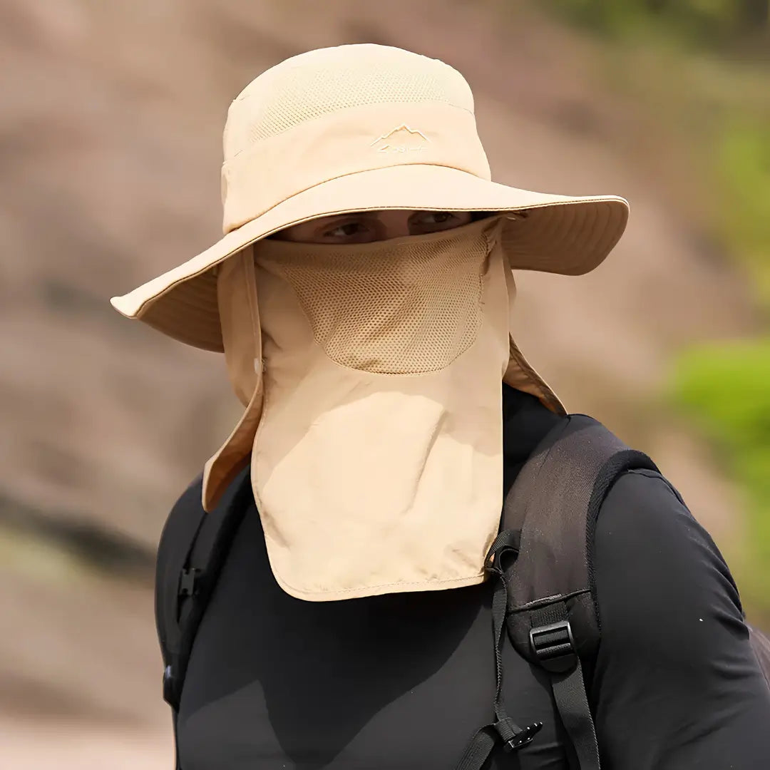 Um aventureiro usando o Chapéu de Pesca Expedition Pro de secagem rápida na cor caqui, com seu rosto coberto com o protetor do chapéu