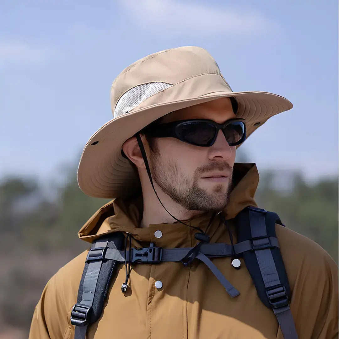 Chapéu de Pesca Zanter Air Field caqui usado por um pescador com jaqueta e mochila, ele está com um óculos escuro no rosto