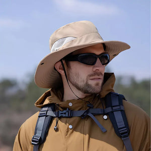 Chapéu de Pesca Zanter Air Field caqui usado por um pescador com jaqueta e mochila, ele está com um óculos escuro no rosto