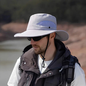 Chapéu de Pesca Zanter Air Field cinza-claro usado um pescador, com destaque para seu cordão de ajuste, sua tela em mesh e sua aba larga