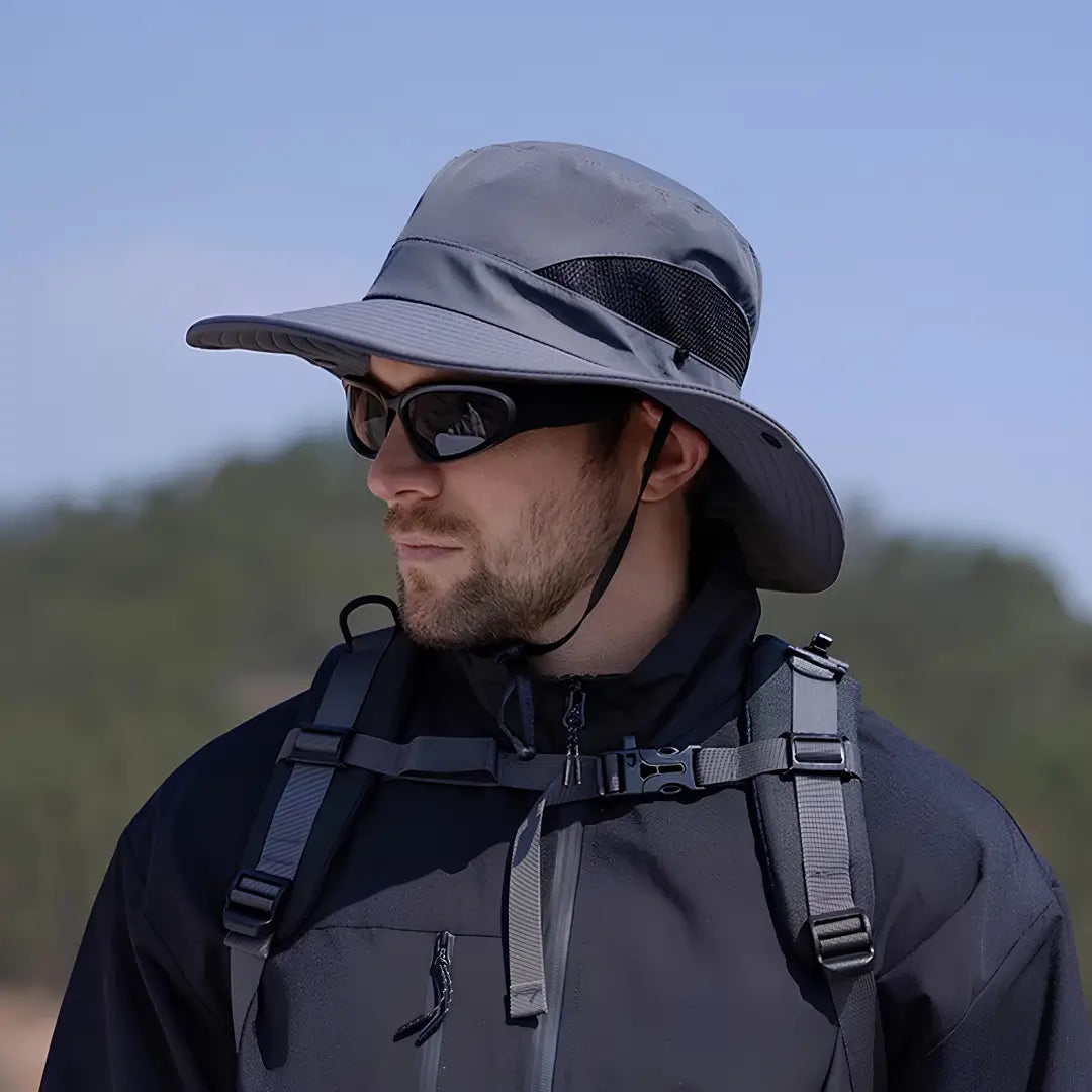 Chapéu de Pesca Zanter Air Field cinza-escuro usado por um pescador visto de lado, com sua tela respirável e sua aba larga