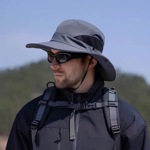 Chapéu de Pesca Zanter Air Field cinza-escuro usado por um pescador visto de lado, com sua tela respirável e sua aba larga