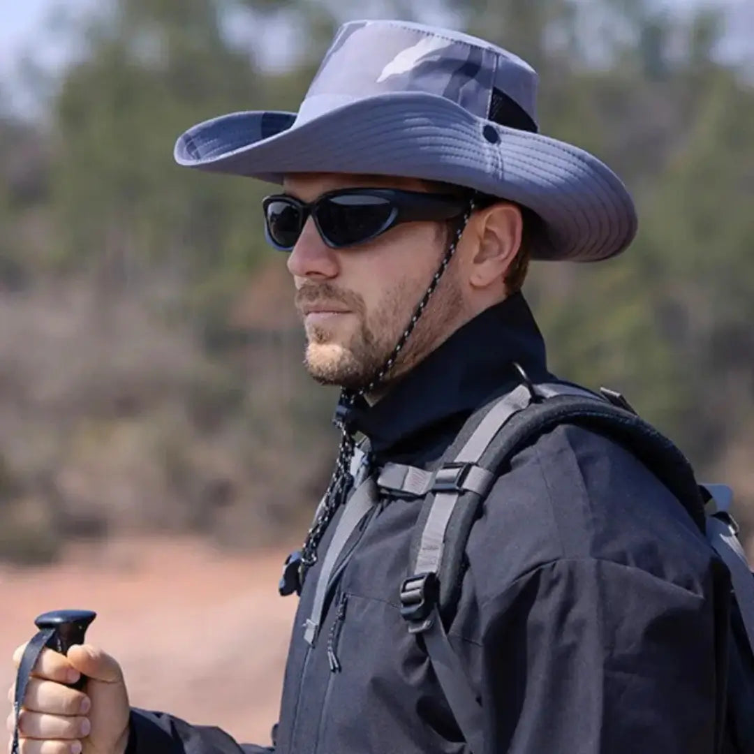 Um pescador mostrando de lado usando um óculos escuro e também usando o Chapéu de Pesca Zanter Camo Trek na cor azul