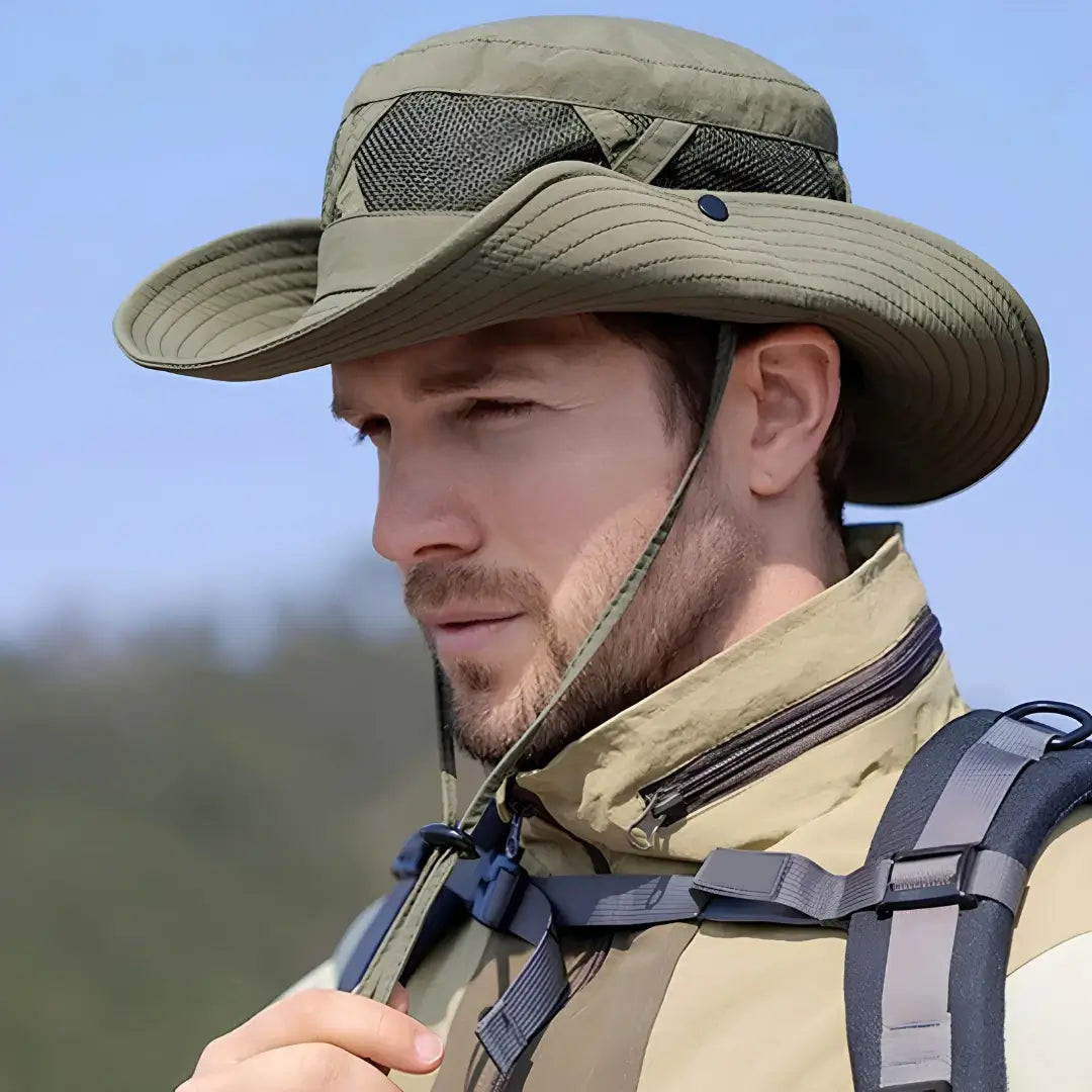Um pescador com o Chapéu de Pesca Zanter Hunter na cor verde na cabeça, ele está ajustando o cordão do queixo do chapéu