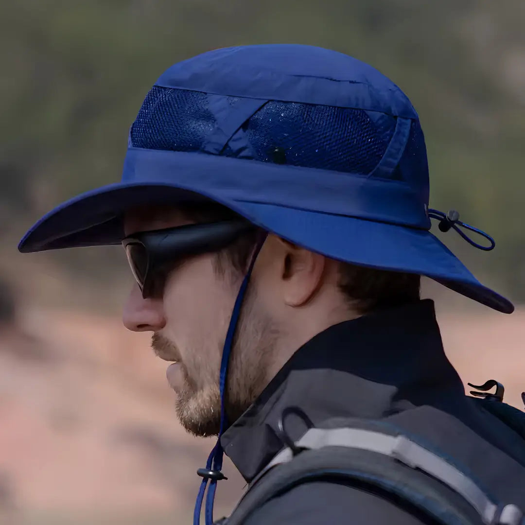 Visão lateral de um pescador usando o Chapéu de Pesca Zanter hunter na cor azul, com seu ajuste de cabeça na parte traseira e seu ajuste de queixo
