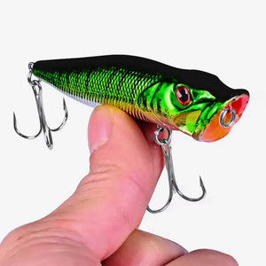 Isca Artificial Popper Pro X na cor sapinho sendo segurada na mão, com seus detalhes em foco