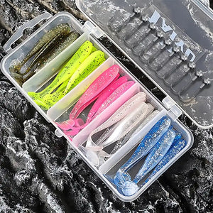 Estojo de iscas artificiais soft shad coloridas aberto sobre rochas escuras, com tampa parcialmente visível