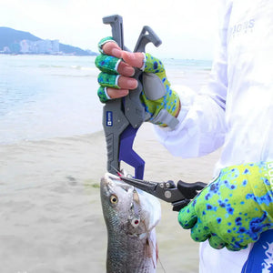 Pescador tirando a isca artificial da boca do peixe com o alicate Carbon, enquanto segura o peixe com o alicate de contenção Clamp