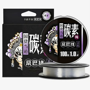 A caixa da Linha Fluorcarbono Zanter Kenshi do lado esquerdo, com dois carretéis do lado direito, um deitado e o outro em cima dele em pé