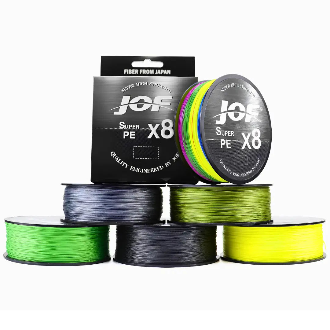 Seis carreteis e a caixa da Linha Multifilamento JOF Pure em cores variadas em destaque, cinco carretéis estão deitados e um está em pé ao lado de sua caixa